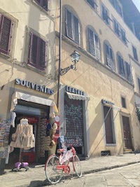 a red bicycle is parked in front of a building