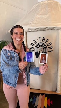 a woman holding up a photo in front of a yurt