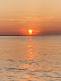 the sun is setting over a body of water