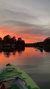 a kayak on the water with a sunset in the background