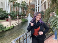 a woman posing for a picture in front of a fountain