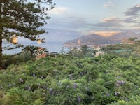 a view of the sea and mountains from the balcony of a hotel