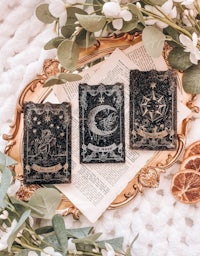 three tarot cards on a gold plate